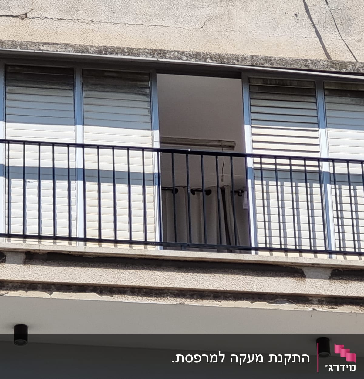 מרפסת עם מסגרת מתכתית וסורגים שחורים